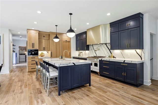 kitchen featuring wall chimney exhaust hood, double oven range, tasteful backsplash, light wood-type flooring, and oven