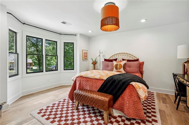 bedroom with light wood finished floors, recessed lighting, and baseboards