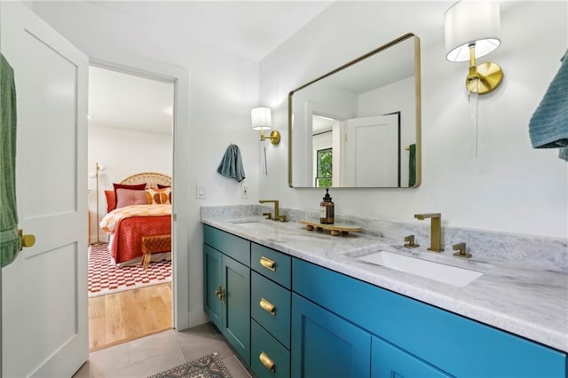 ensuite bathroom featuring double vanity and tile patterned flooring
