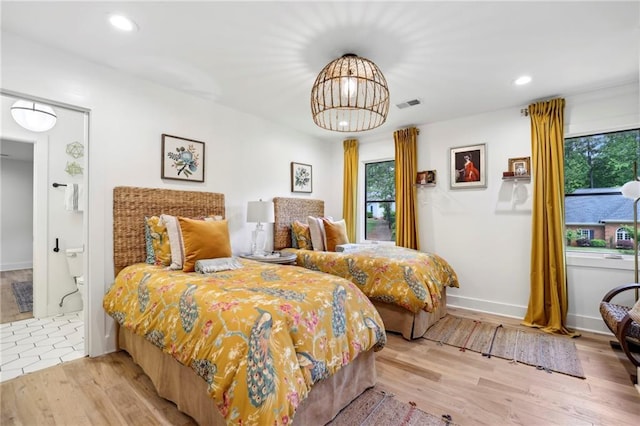 bedroom featuring multiple windows, wood finished floors, recessed lighting, and a chandelier