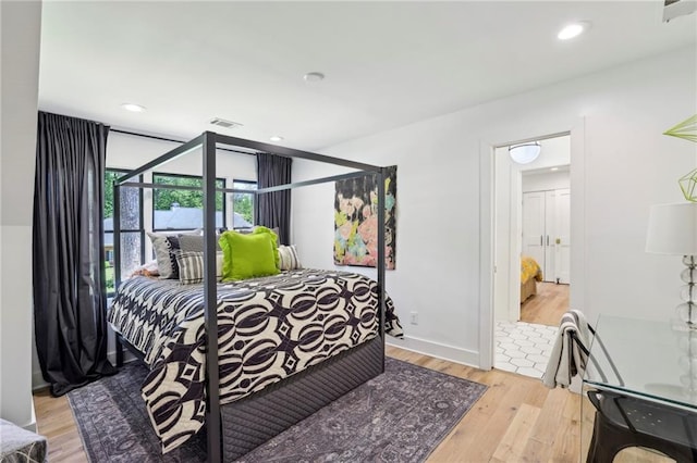 bedroom with light wood-style floors and recessed lighting