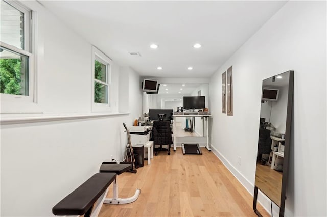 workout area with light wood finished floors, recessed lighting, and baseboards