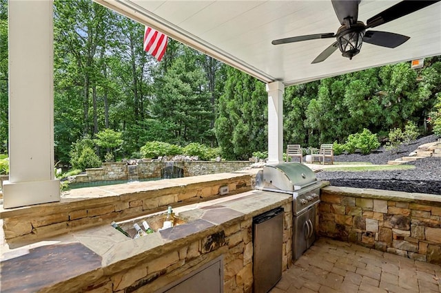 view of patio with exterior kitchen, a ceiling fan, and area for grilling