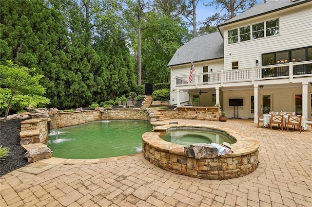 view of pool with a patio area, a pool with connected hot tub, and outdoor dining area