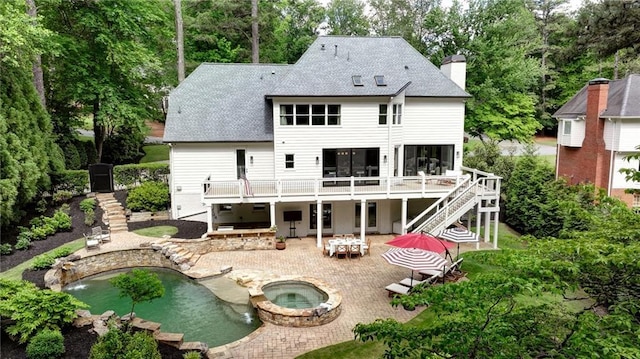rear view of house featuring an in-ground hot tub, stairs, a patio area, a wooden deck, and a shingled roof