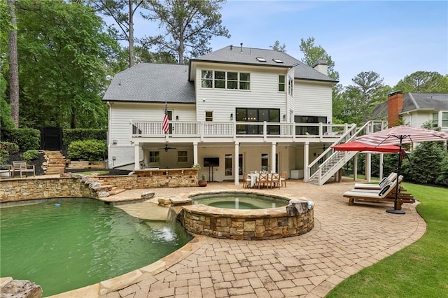 back of property with stairs, a patio, a chimney, a deck, and a shingled roof
