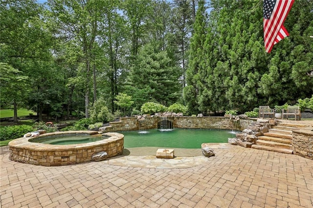 view of patio / terrace with a pool with connected hot tub and view of scattered trees