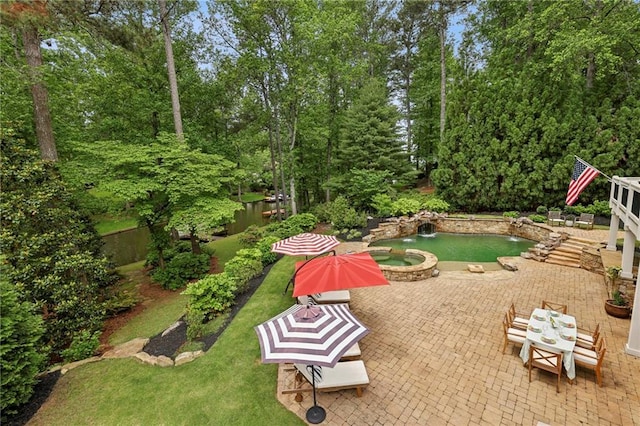 view of yard featuring a patio, a pool with connected hot tub, and fence