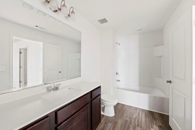 full bathroom with shower / bathing tub combination, vanity, wood-type flooring, and toilet