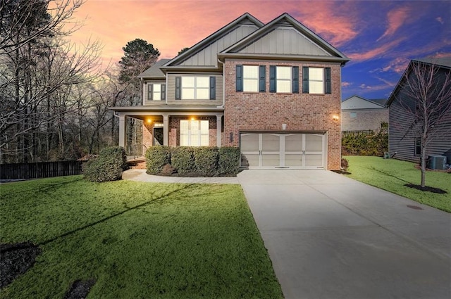 craftsman-style house with central AC unit, a yard, and a garage