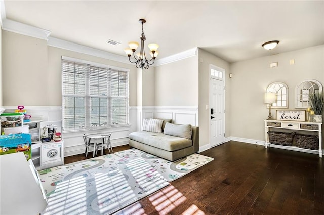 living area featuring ornamental molding, dark hardwood / wood-style floors, and a chandelier