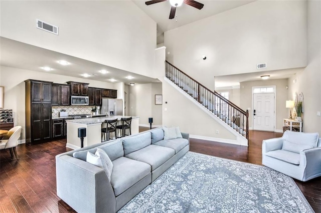 living room featuring high vaulted ceiling, ceiling fan, and dark hardwood / wood-style flooring