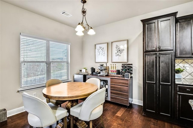 dining area with a chandelier and dark hardwood / wood-style flooring