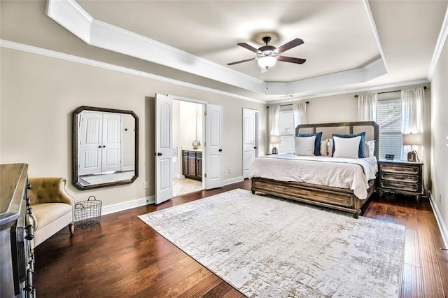 bedroom featuring ensuite bath, a raised ceiling, ceiling fan, ornamental molding, and dark hardwood / wood-style flooring