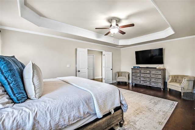 bedroom featuring a raised ceiling, ceiling fan, ornamental molding, and dark wood-type flooring