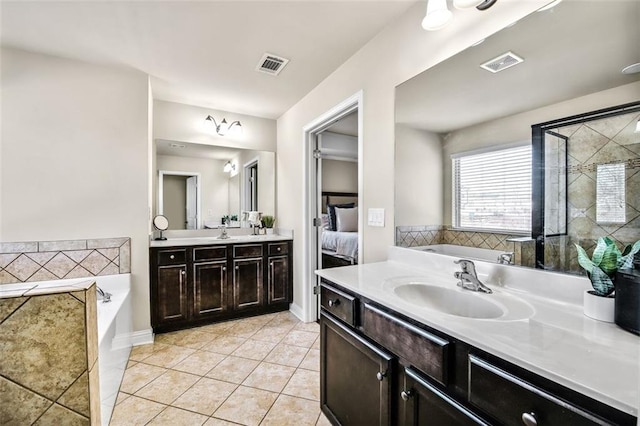 bathroom featuring vanity, tile patterned floors, and a bath