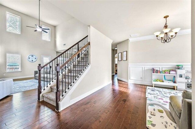 entrance foyer with ornamental molding, dark wood-type flooring, and a notable chandelier