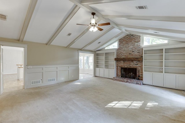 unfurnished living room with lofted ceiling with beams, a fireplace, a healthy amount of sunlight, and light colored carpet