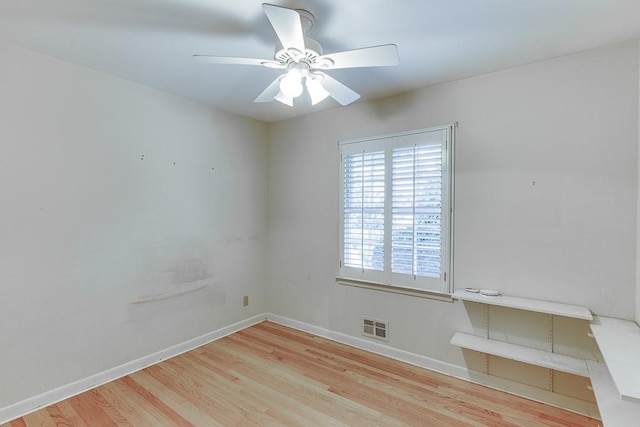 empty room with ceiling fan and light hardwood / wood-style flooring