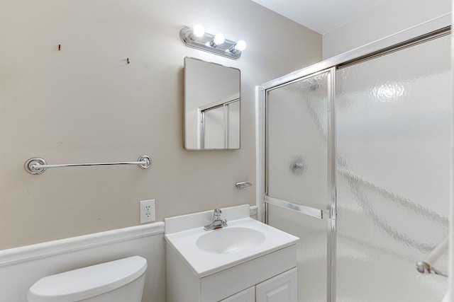 bathroom featuring vanity, toilet, and walk in shower