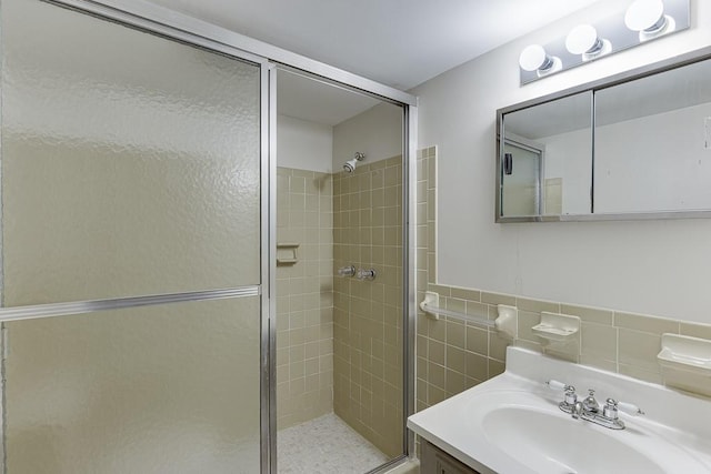 bathroom featuring vanity, tile walls, and a shower with shower door