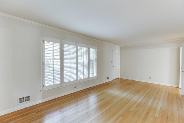 spare room featuring light hardwood / wood-style floors and crown molding