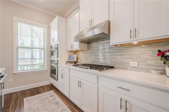 5005 Shay Town Ln, Peachtree Corners, GA 30092 - kitchen featuring crown molding, decorative backsplash, white cabinetry, under cabinet range hood, and stainless steel appliances