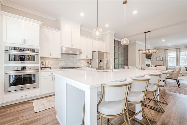 5005 Shay Town Ln, Peachtree Corners, GA 30092 - kitchen with crown molding, backsplash, under cabinet range hood, and stainless steel appliances