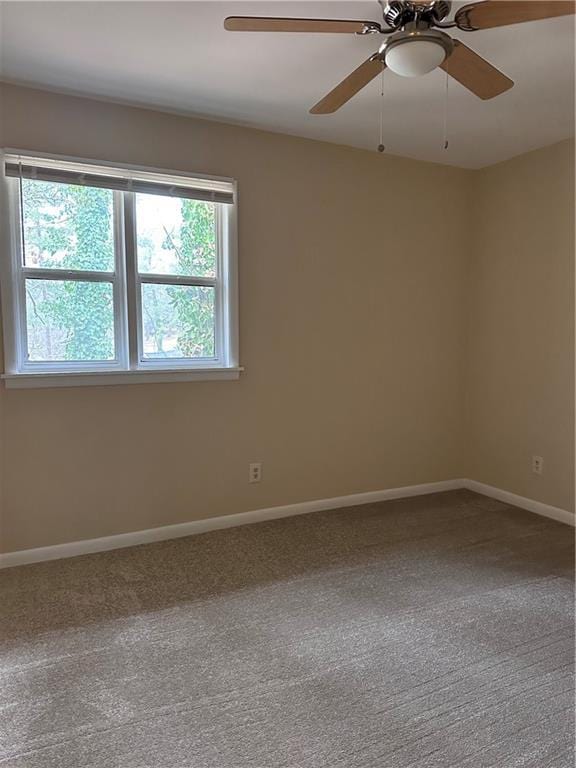 empty room featuring carpet floors, a ceiling fan, and baseboards