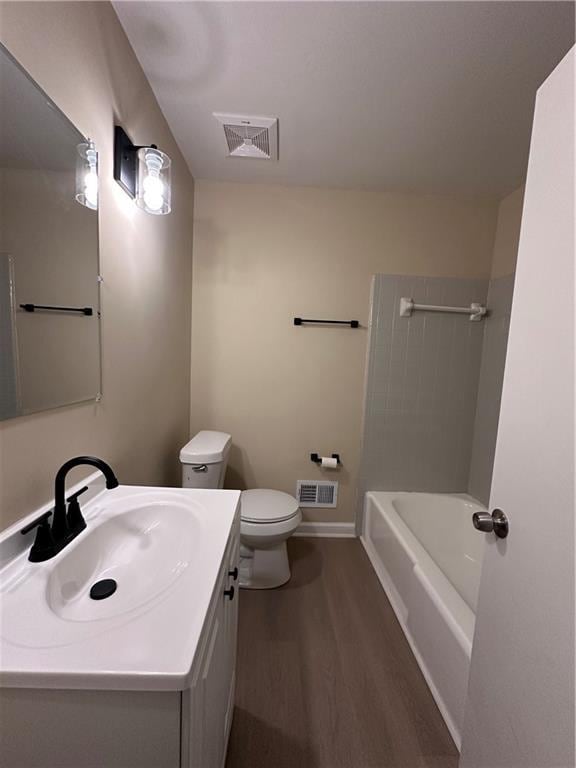 bathroom featuring toilet, visible vents, wood finished floors, and vanity