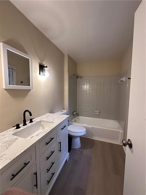 full bathroom with toilet, shower / washtub combination, wood finished floors, and vanity