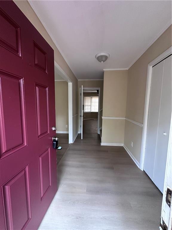 entrance foyer with light wood-style flooring, baseboards, and ornamental molding