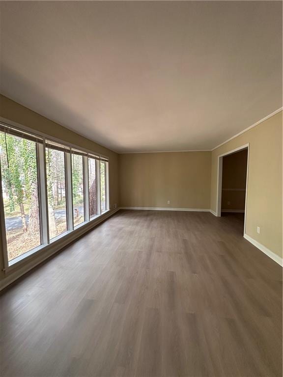 unfurnished living room with baseboards and wood finished floors