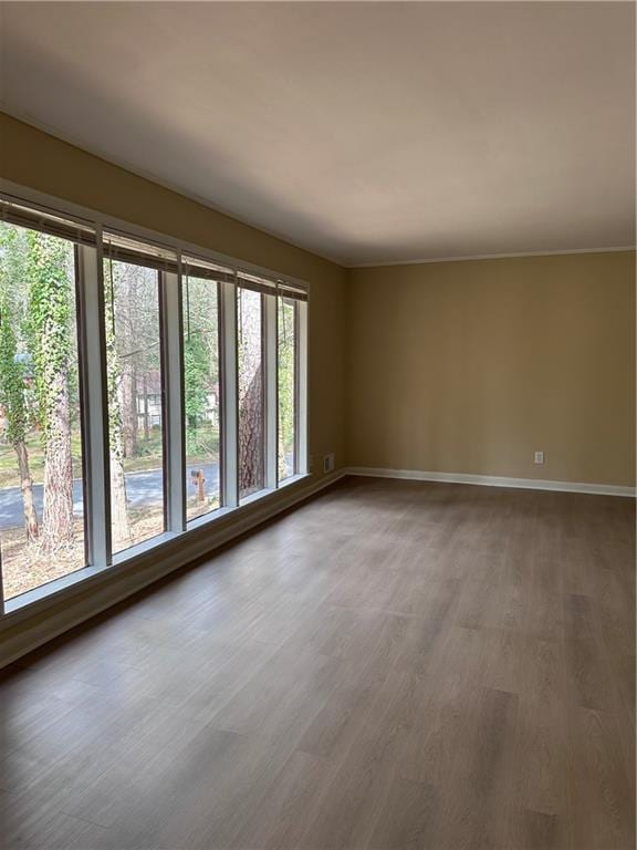 empty room with baseboards and wood finished floors