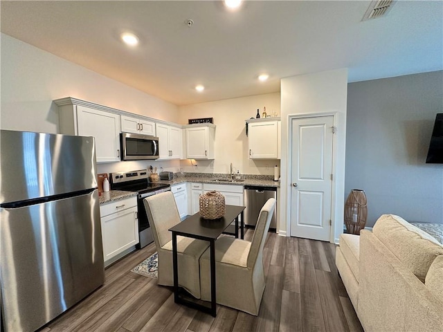 544 Magnolia Cir, Palmetto, GA 30268 - kitchen featuring stainless steel appliances, dark wood finished floors, white cabinetry, recessed lighting, and light stone counters