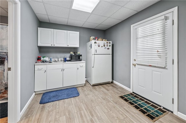 2012 Arbor Springs Way, Buford, GA 30519 - kitchen with freestanding refrigerator, black microwave, a paneled ceiling, light wood-style floors, and white cabinetry