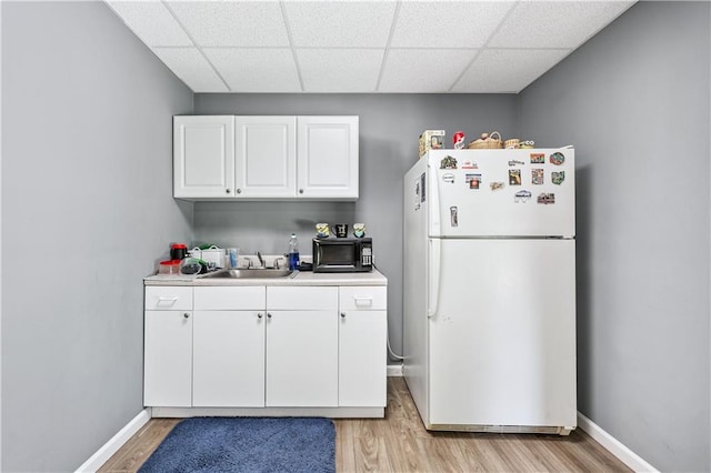 2012 Arbor Springs Way, Buford, GA 30519 - kitchen featuring freestanding refrigerator, black microwave, a paneled ceiling, light countertops, and white cabinets