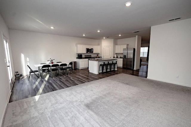 dining area featuring dark wood-style floors, dark carpet, visible vents, and recessed lighting