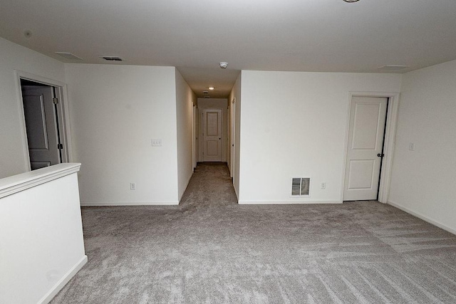 carpeted empty room with visible vents and baseboards