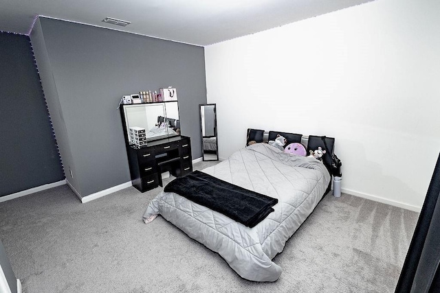 bedroom with carpet floors, visible vents, and baseboards