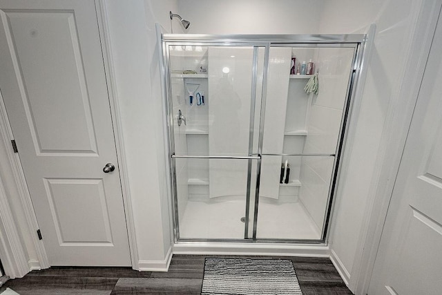 full bath with a stall shower and wood finished floors