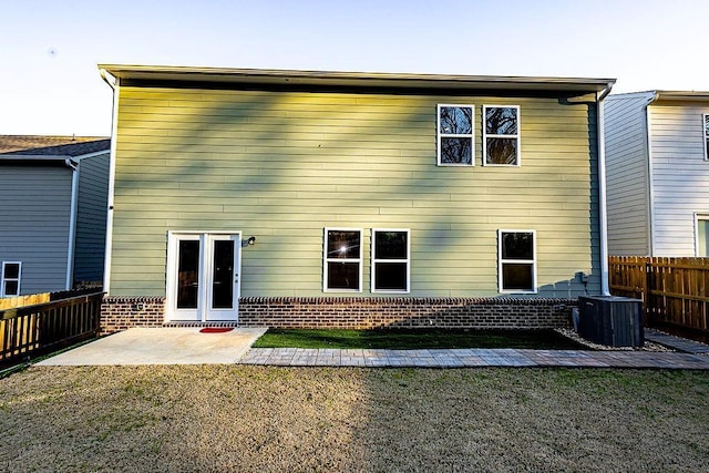 rear view of house featuring cooling unit, brick siding, fence, a lawn, and a patio area