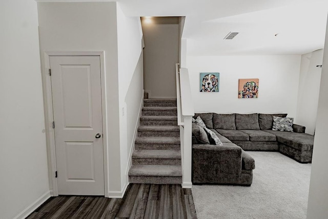 living area with stairway, baseboards, dark wood-style floors, and visible vents