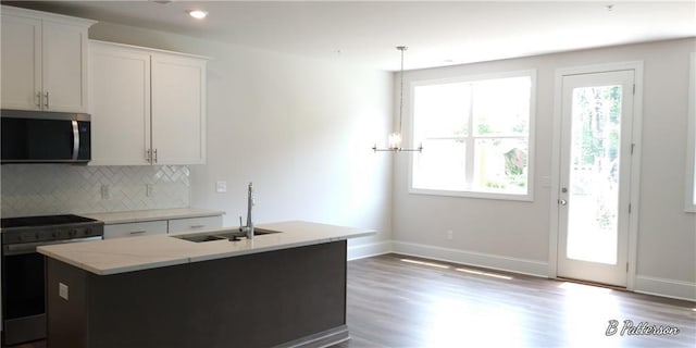 1071 Crest Mill Dr, Marietta, GA 30008 - kitchen with stainless steel appliances, backsplash, wood finished floors, a kitchen island with sink, and light stone counters