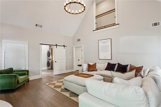 2721 Old Concord Rd SE, Smyrna, GA 30082 - living area with stacked washer / drying machine, high vaulted ceiling, a barn door, baseboards, and a chandelier
