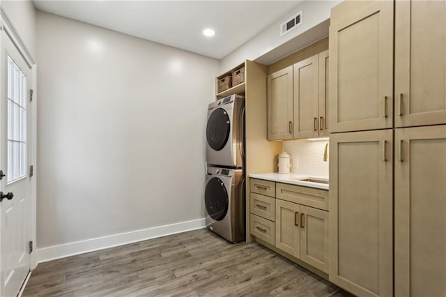2721 Old Concord Rd SE, Smyrna, GA 30082 - washroom featuring estacked washer and dryer, cabinet space, light wood-type flooring, baseboards, and recessed lighting