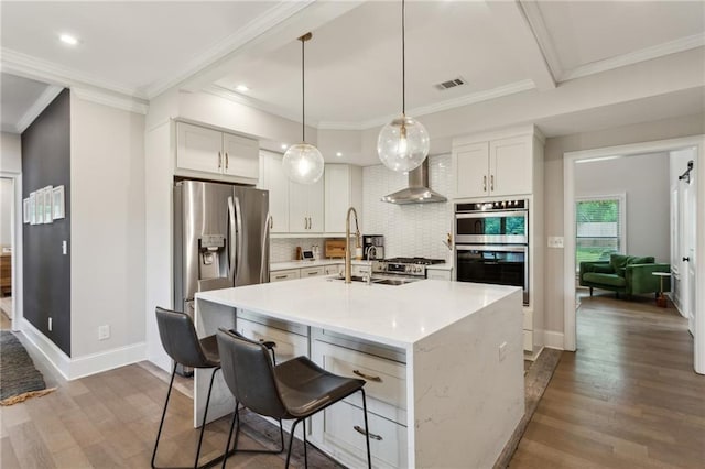 2721 Old Concord Rd SE, Smyrna, GA 30082 - kitchen featuring wall chimney exhaust hood, wood finished floors, tasteful backsplash, stainless steel appliances, and light countertops