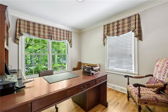 office area featuring baseboards, ornamental molding, and light wood finished floors