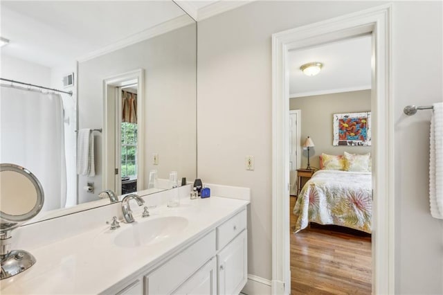 ensuite bathroom featuring wood finished floors, connected bathroom, vanity, visible vents, and crown molding