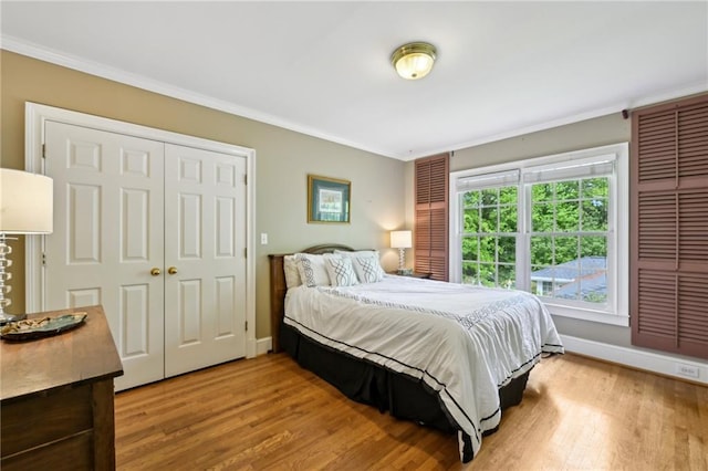 bedroom featuring baseboards, ornamental molding, and light wood finished floors